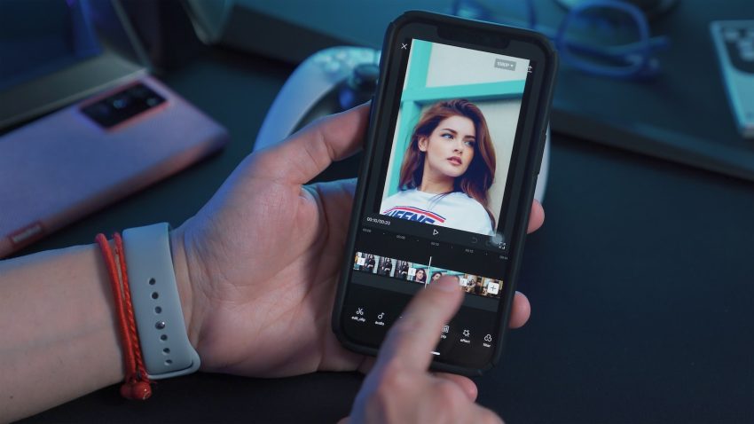 a person holding a cell phone with a picture of a woman on the screen