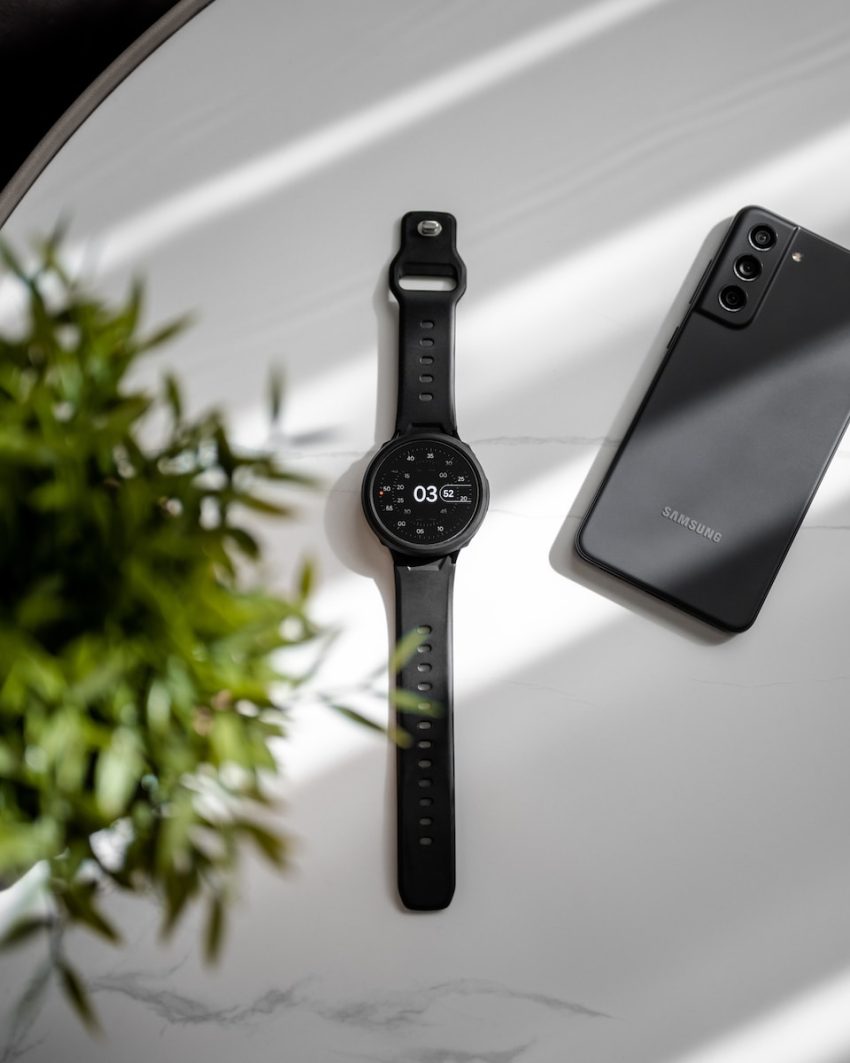 a smart watch sitting next to a cell phone